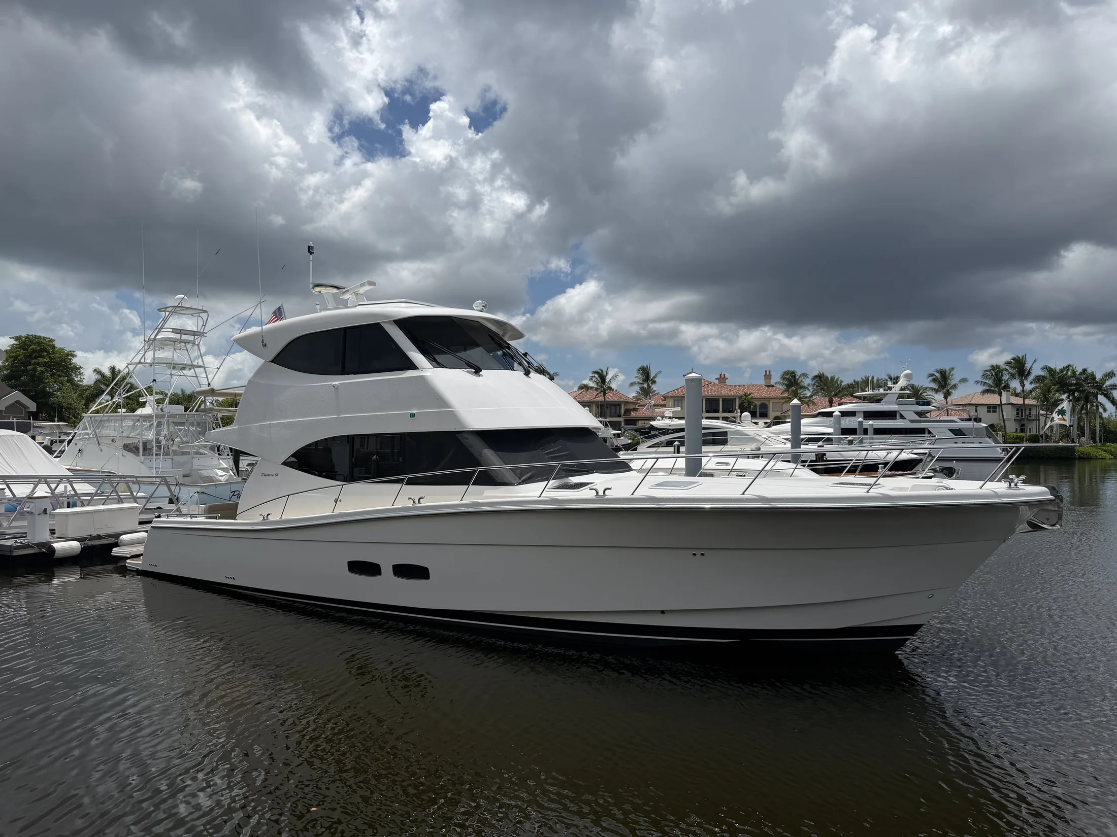 White sport-fishing yacht docked at a marina