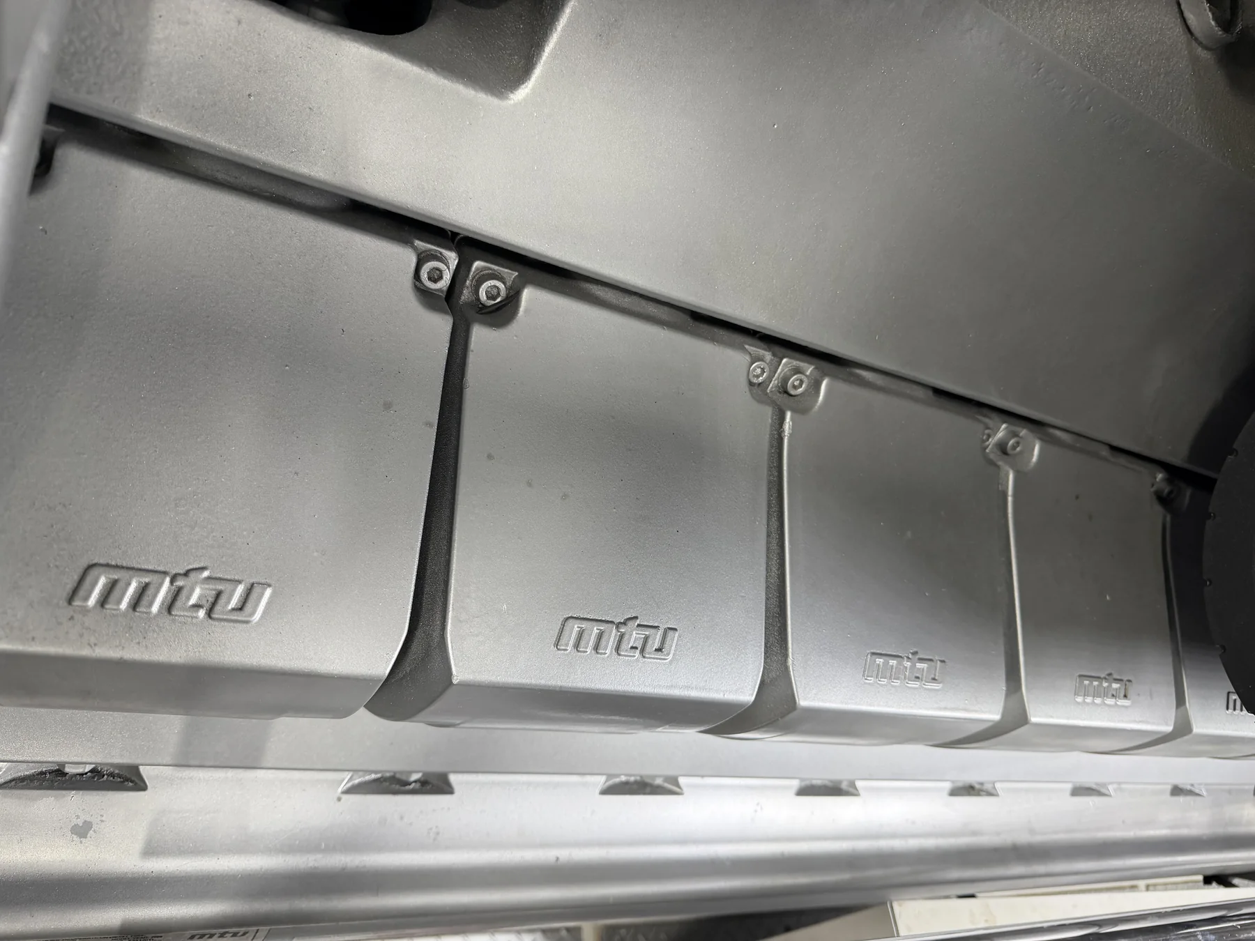 Several silver MTU-labeled engine covers in a yacht engine room.